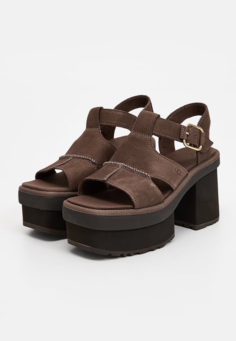 Sandalias de plataforma de ante marrón con diseño de tiras cruzadas, hebilla ajustable, acabado texturizado y suela de goma gruesa para mayor estabilidad.