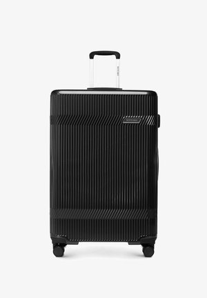 Zwarte harde koffer met verticale ribbels, telescopisch handvat, vier wielen en Wittchen merklogo aan de voorkant.