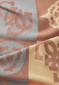 Sciarpa tessuta caratterizzata da una miscela di fibre morbide. I colori includono grigio, marrone e giallo con grandi motivi logo in un design ripetuto.