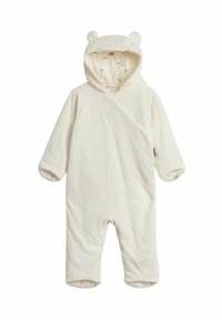 Krämfärgad babysuite gjord av mjukt tyg med en huva som har björnohr. Mönstrad foder med små, subtila mönster.