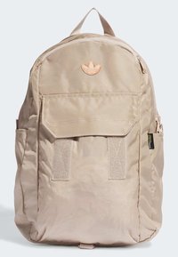 Beige fabric backpack with a front flap pocket, zipper closure, textured finish, and a contrasting orange logo patch at the top.