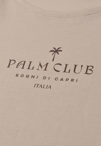 Beige fabric with black text reading "Palm Club," a palm tree icon, "Sogni di Capri," and "Italia" below.