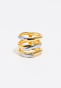Anillo de tres bandas con un diseño de metal trenzado en oro y plata. Acabado brillante con textura suave y formas entrelazadas.