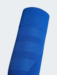 Bright blue športová ponožka s textúrovaným pleteným vzorom a rebrovaným lemeňom pre štýl a pohodlie. Vhodná na šport alebo na bežné nosenie.