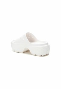 Zuecos de plástico blanco con una superficie lisa, diseño redondeado, orificios de ventilación, tacón texturizado y una suela gruesa y ligera.