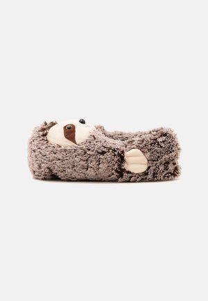 Chausson en peluche conçu comme un paresseux avec une fourrure douce marron, un visage beige et une petite patte brodée sur le côté.