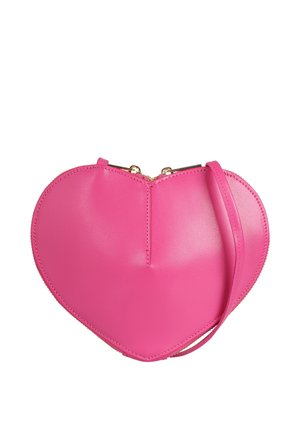 Sac à main en cuir rose vif en forme de cœur avec double fermeture éclair dorée et une sangle assortie pour le poignet sur fond blanc.