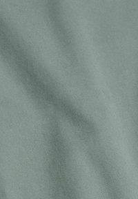 Textured fabric in a muted teal color, showing a subtle diagonal rib pattern and a smooth surface with slight sheen.