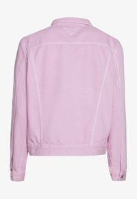 Chaqueta de mezclilla rosa con cuello clásico, mangas largas y puño abotonado. Presenta yugo trasero y detalles de costura para dar textura.