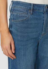 Blauwe denim jeans met een hoge taille, klassiek vijf-pocket ontwerp, subtiele vervaging en contrasterende stiksels. Glad textuur met een gestructureerde pasvorm.