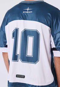 Vista posteriore di una persona che indossa una maglia sportiva blu e bianca con il numero 10 e il logo PXP sulla schiena.