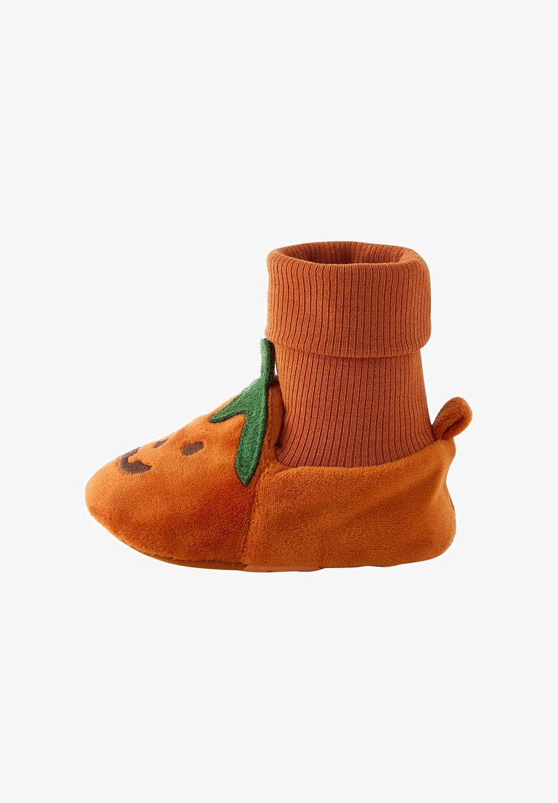 Chausson orange doux pour enfant en bas âge avec un visage de citrouille souriant, détail de feuille verte et bord-côte côtelé pour un ajustement confortable.