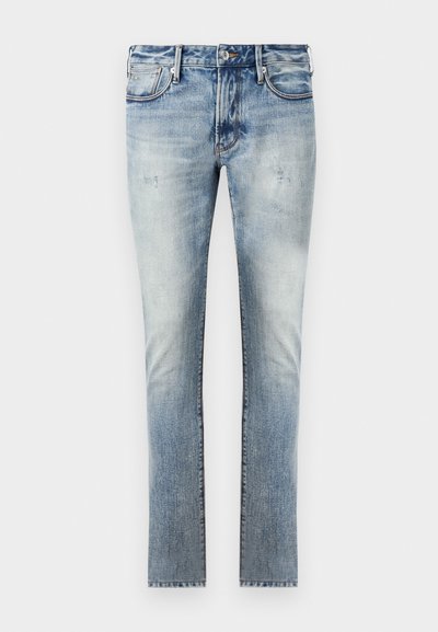 Calças de ganga azul claro com um acabamento desbotado, design ajustado, cinco bolsos e costuras contrastantes nas emendas.