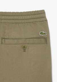 Khaki shorts met een elastische tailleband, een achterzak met een knoop en een klein groen krokodil logo. Zacht, lichtgewicht stof.