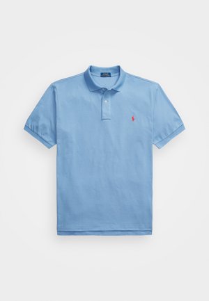 Light blue polo shirt made of cotton with a collared neck. Features short sleeves and a small red logo on the left chest. Smooth texture.