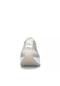 Sneaker beige con tomaia in rete, lacci bianchi e una suola spessa bianca. Presenta dettagli metallici e un tallone testurizzato per il supporto.