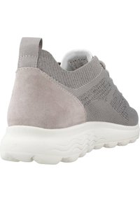 Sneaker grigio chiaro con tomaia in maglia testurizzata, accentuazione in suede sulla parte posteriore e suola in gomma bianca con un motivo ondulato.