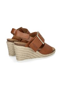 Bruine leren wedge sandalen met een gevlochten jute zool, voorzien van een brede band en een metalen gespaccent. Gevarieerde binnenzool voor comfort.