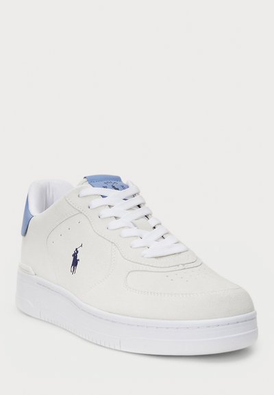 White suede sneakers with a blue heel accent, white laces, and perforated toe. Features a logo in dark blue on the outer side.