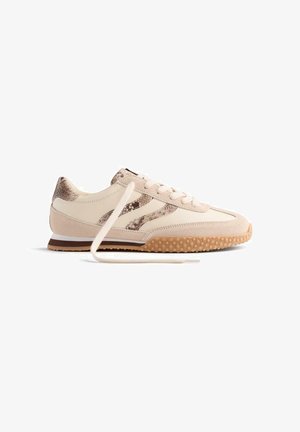 Sneakers con tomaia in pelle bianca, dettagli a motivo serpente e rinforzi in suede beige. Punta rotonda, design con lacci e suola in gomma.