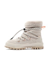 Bottines en suède beige avec un col en fourrure, des lacets rayés noir et blanc, des accents orange et une semelle en caoutchouc beige robuste.