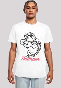 Hvit bomull T-skjorte med svart linjetegnende kaninfigur Thumper og rosa tekst nedenfor. Modellen har på seg en avslappet passform med rund hals.
