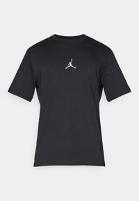 Svarte bomull t-skjorte med korte ermer, rund hals og en hvit Jumpman-logo plassert på brystet. Jevn tekstur med en klassisk passform.