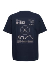 Granatowy T-shirt z dużym beżowym nadrukiem na plecach, zawierającym liczby, tekst, okrągły wzór "Off Duty Gear" oraz sylwetkę gór.