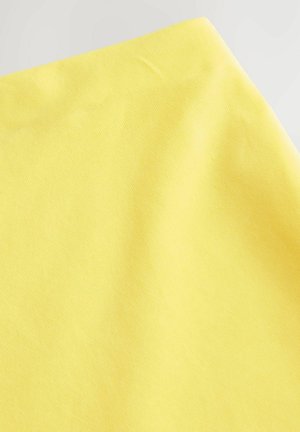 Helle gelbe Stoff mit glatter Textur und subtilem geripptem Muster, gefaltet und leicht zerknittert, der seine lebendige Farbe zur Geltung bringt.