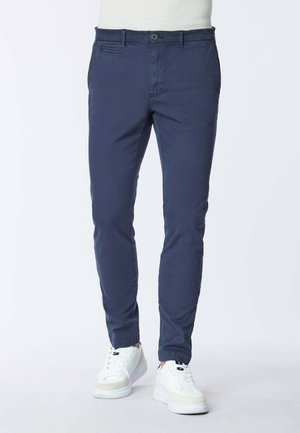 Chino blu navy con vestibilità slim, realizzati in tessuto misto cotone. Presentano tasche frontali, zip centrale e chiusura con un singolo bottone.