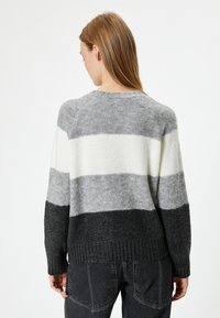 Texturiertes Sweatshirt mit horizontalen Streifen in Grautönen und Weiß, mit geripptem Saum und rundem Ausschnitt. Weiches, warmes Material.