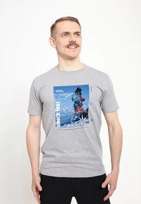 Szara bawełniana koszulka z grafikiem, w różnych odcieniach niebieskiego, z napisem "SINCE 1981" i ilustracją tematyki outdoorowej. Krótkie rękawy.