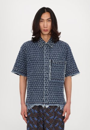 Denimhemd mit einem strukturierten blauen Muster, kurzen Ärmeln, fransigem Saum und einer einzelnen Brusttasche. Verfügt über kontrastierende Nähte.