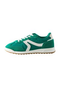 Chaussure de sport verte avec un mélange de daim et de textile lisse, accents blancs, et une semelle en gomme texturée avec un design à profil bas.