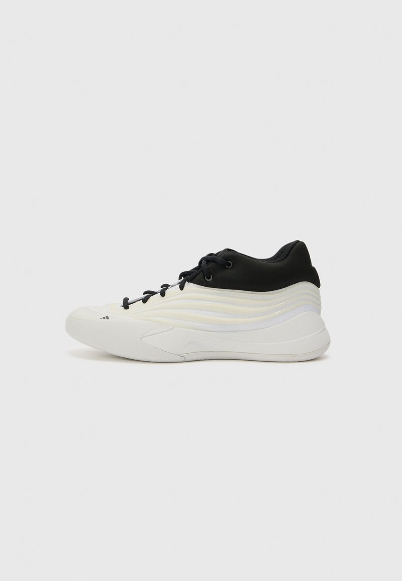 Sneaker con una parte superiore nera e una parte inferiore bianca testurizzata, design elegante e un motivo distintivo a onde in tonalità di grigio chiaro.