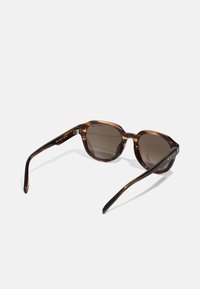 Ochelari de soare cu model tartan, cu formă rotundă, lentile de culoare maro închis, și brate elegante cu un branding subtil. Finisaj neted și lucios.