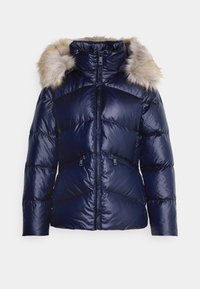 Marinblå pufferjacka med en huva klädd med fuskpäls, dragkedjestängning, sidofickor och en sydd, kviltad mönstring för isolering.