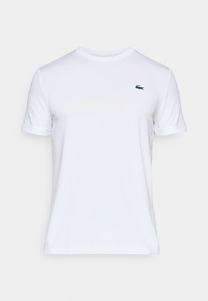 Witte katoen t-shirt met korte mouwen, ronde halslijn, subtiele gele Lacoste branding en een klein groen krokodillenlogo op de borst.