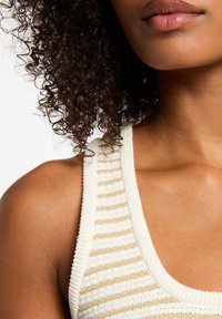 Cream and gold striped knit tank top with a ribbed texture and wide straps, featuring a scoop neckline and no visible hardware.