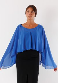 Top blu con cappotto trasparente, scollatura rotonda e maniche a batwing fluide. Abbinato a una gonna aderente nera con uno spacco frontale.