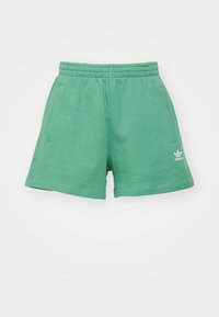 Zelené bavlněné šortky s elastickým pasem, bočními kapsami a bílým logem na lemu. Hladká textura a ležérní design.