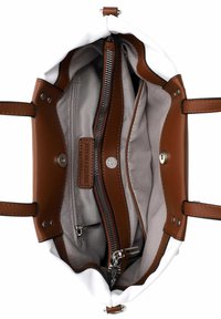 Interno della borsa bianca con dettagli in pelle marrone. Presenta più scomparti, una tasca con zip e chiusura a scatto. Texture liscia in tutto il design.
