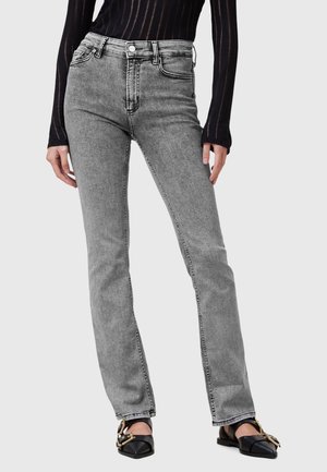 Jeans grigi alti in vita con vestibilità dritta, caratterizzati da cuciture visibili e design a cinque tasche, abbinati a scarpe basse nere.