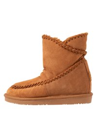 Bottes de cheville en daim beige avec des coutures décoratives, une texture douce et un bout arrondi. Elles sont dotées d'une semelle en caoutchouc plat pour plus de confort et de durabilité.