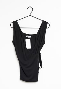 Haut sans manches noir avec un design enroulé, fabriqué dans un tissu doux. Présente un décolleté et un détail de nœud sur le côté. Étiquette attachée pour la taille.