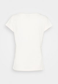 Camiseta de algodón blanca con mangas cortas, corte relajado y escote redondo. Textura suave, sin patrones ni diseños visibles.