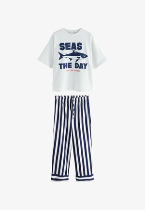 Vit bomull t-shirt med en marinblå "SEAS THE DAY" grafik och hajdesign; tillsammans med marinblå och vita randiga byxor med elastisk midja.