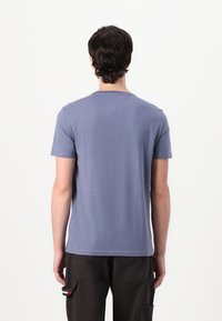 T-shirt s kratkimi rokavi, krojač s kroga v svetlo modri barvi, izdelan iz mehke bombažne tkanine. Ima raven hem in minimalne šive.