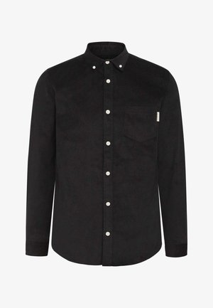 Chemise en velours côtelé noir avec un col boutonné, des manches longues et une poche sur la poitrine. Présente des boutons blancs et un tissu texturé.