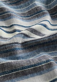 Tkana tkanina z poziomymi paskami w odcieniach granatowym, jasnoniebieskim i białym. Miękka struktura z połączeniem kolorów i różnymi szerokościami pasków.